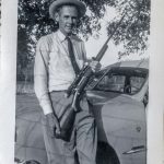 An image of Mr. Cage and his rifle